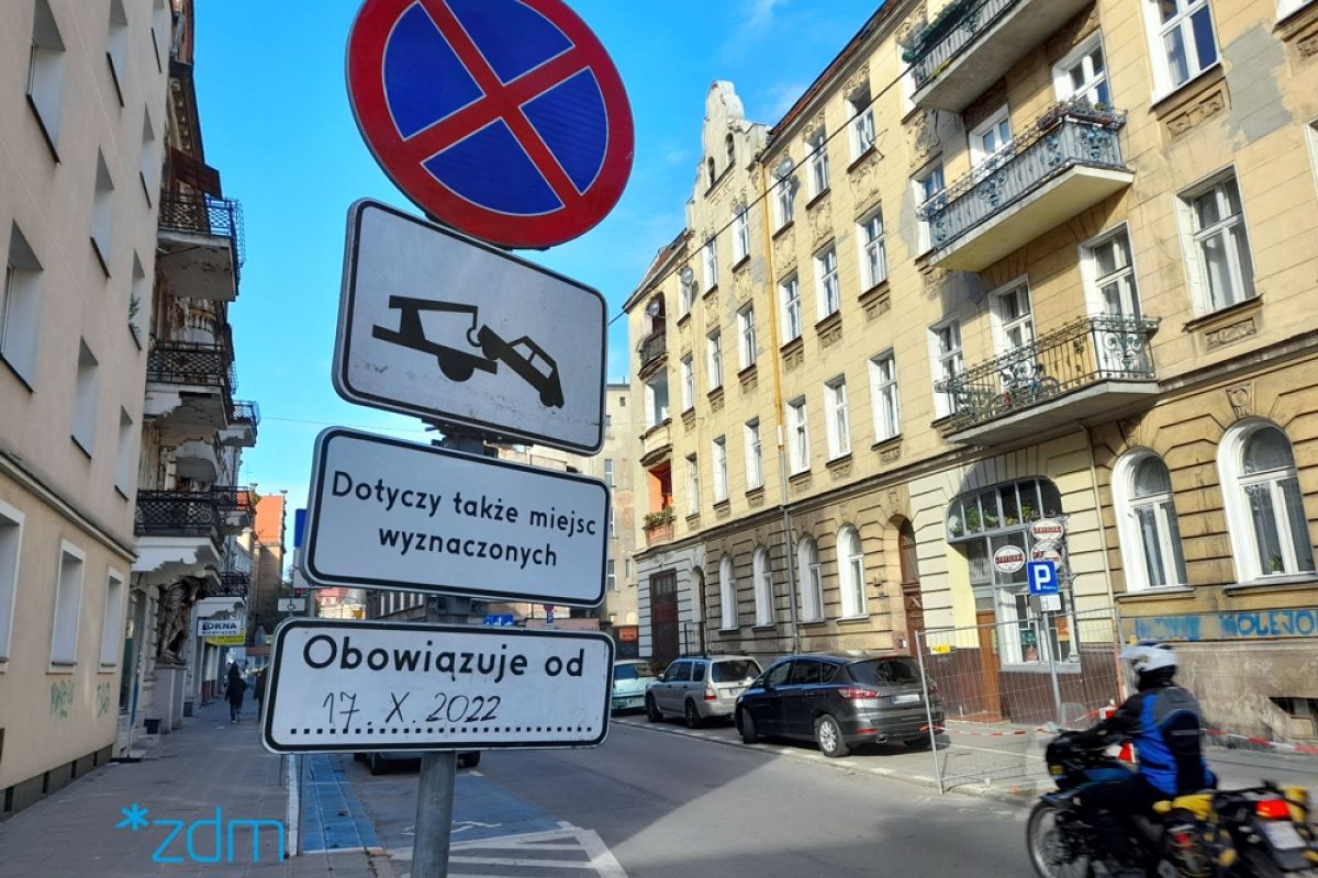 Znak zatrzymywania się ustawiony na ulicy z tabliczką informującą o możliwości odholowania samochodu