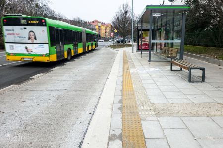 Platforma i wiata przystankowa. Po lewej stronie odjeżdżający autobus.