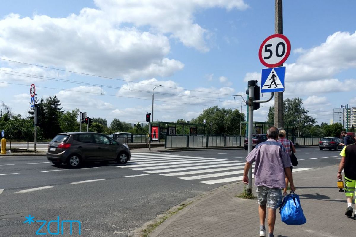 UlicaHetmańska w Poznaniu. Znak informujący o ograniczeniu prędkości do 50 km/h. W tle przejście dla pieszych i jezdnia