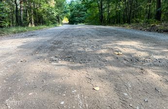 Nawierzchnia ulicy z wyraźnymi ubytkami na środku