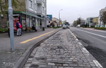 Zniszczona zatoka autobusowa z kostki kamiennej.