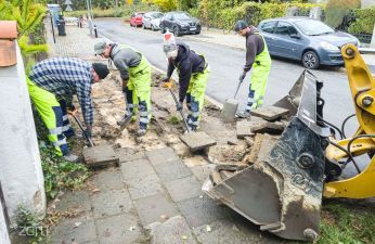 Pracownicy usuwający zniszczone płyty chodnikowe