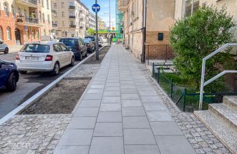 Widok na wyremontowany chodnik na ul. Fabrycznej, z lewej strony widoczne samochody.