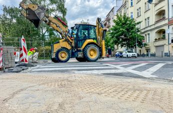 Sprzęt budowlany pracuje w rejonie prac na przejściu dla pieszych