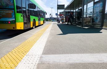 Fakturowe oznaczenia nawierzchni wraz z przystankiem i zaparkowanym w zatoczce autobusem