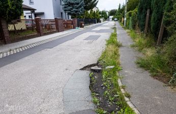 Ulica Notecka z zakrętem, widoczne wyraźnie zniszczony pas drogowy i wpust kanalizacyjny