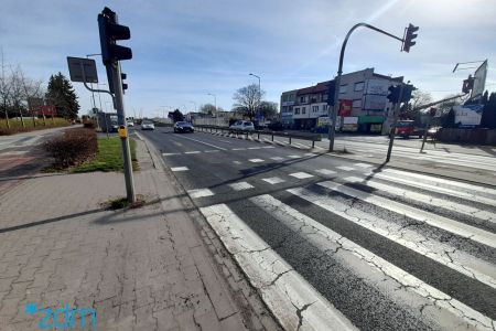 Przejście dla pieszych z sygnalizacją na ul. Głogowskiej. Na jezdni zniszczona nawierzchnia