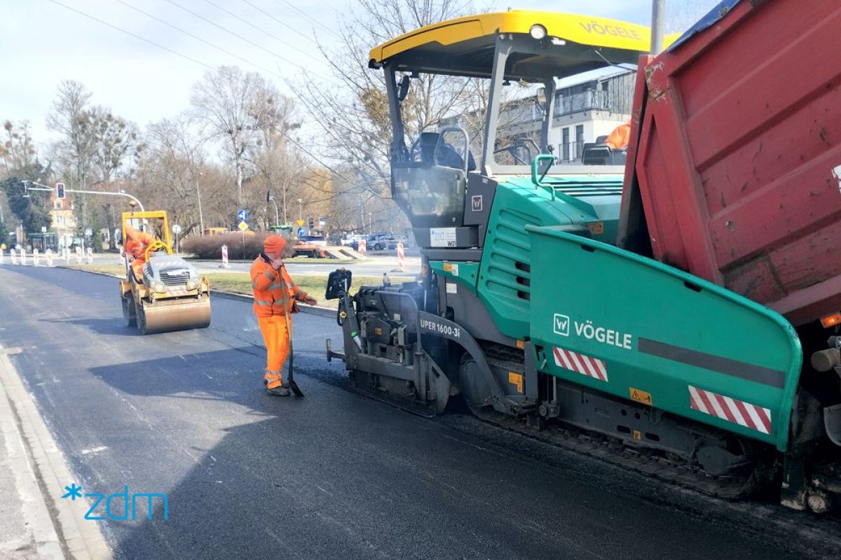 Układarka asfaltu i robotnicy na remontowanej ulicy