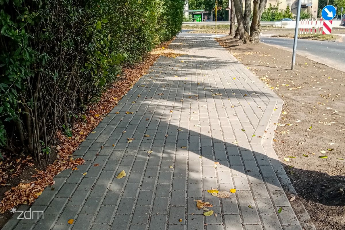 Po lewej stronie ogrodzenie, na środku chodnika, po prawej pas na którym posadzona będzie zieleń