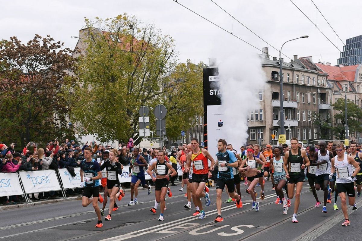 Biegacze w strojach sportowych biegnacy ulicą Grunwaldzką 