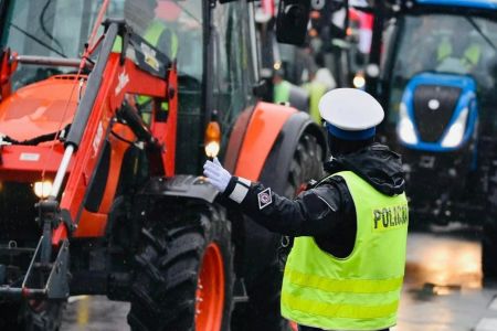 Traktory i stojący przed nimi policjant