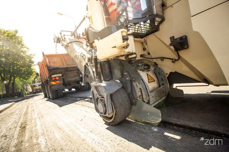 Maszyny drogowców i robotnicy na remontowanej ulicy